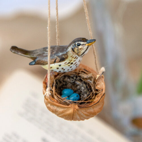 Miniature Handmade Song Thrush on a walnut shell nest with realistic replica eggs hanging decoration