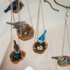 Range of miniature handmade British birds made from polymer clay on a macrame walnut shell nest with replica eggs