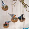 Range of miniature handmade British birds made from polymer clay on a macrame walnut shell nest with replica eggs