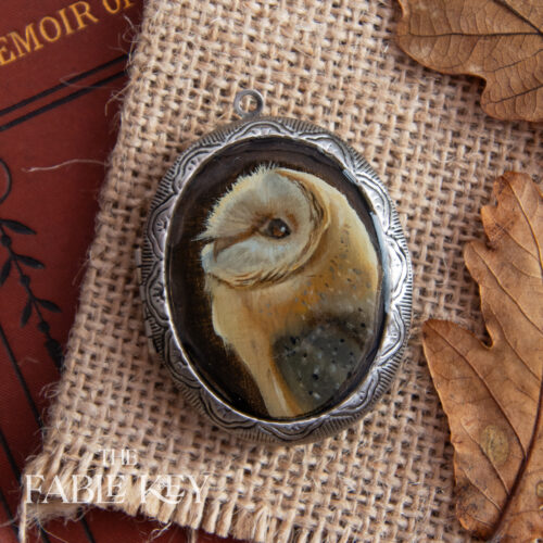 Victorian style hand painted locket featuring a barn owl feather